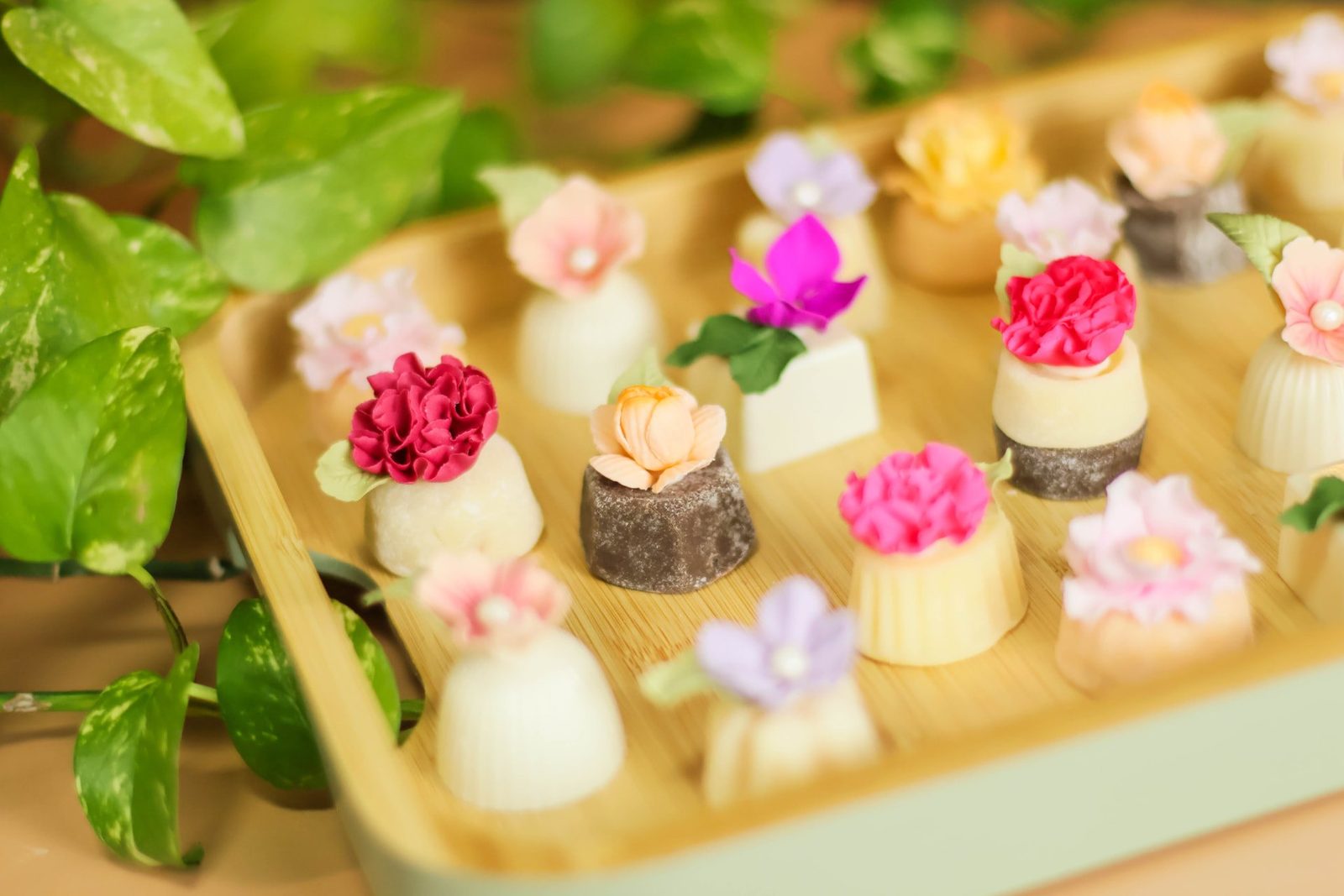 Brigadeiros finos com flores de açúcar em bandeja dourada